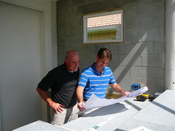 Two men looking at a construction plan.